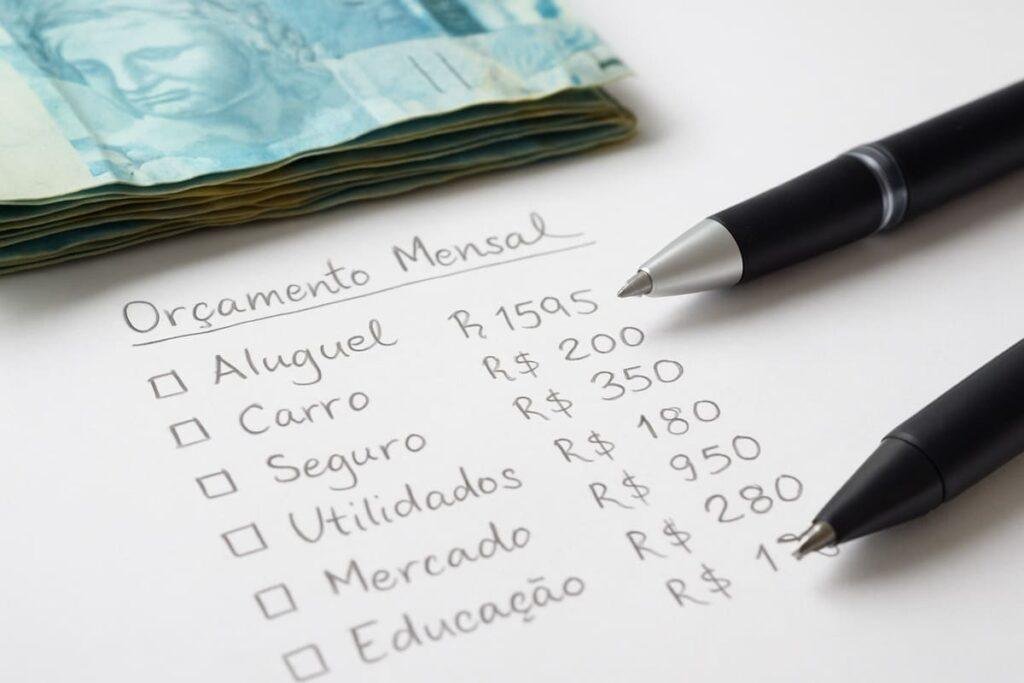 Imagem de cédulas de real e planilha de gastos criando orçamento mensal com prompts para organização financeira