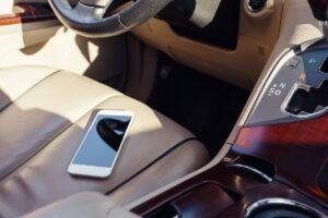 Foto de um celular sobre o banco de um carro - habitos que danificam os eletronicos