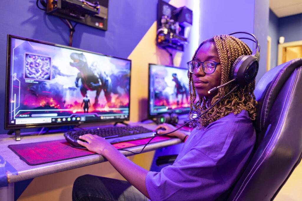 Foto de uma garota gamer jogando, representando a diferença entre PC Gamer vs PC Comum